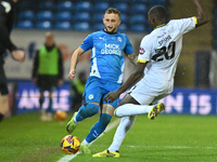 Sam Curtis of Peterborough United challenges Jason Sraha of Burton Albion during the Sky Bet League 1 match between Peterborough United and...