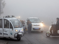 Citizens ride in heavy fog with visibility of less than 100 meters on a street in Hua County, Anyang, China, on December 5, 2024. (