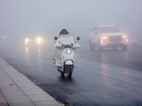 Citizens ride in heavy fog with visibility of less than 100 meters on a street in Hua County, Anyang, China, on December 5, 2024. (