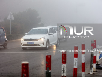 Cars travel in heavy fog with visibility of less than 100 meters on a street in Hua County, Anyang, China, on December 5, 2024. (