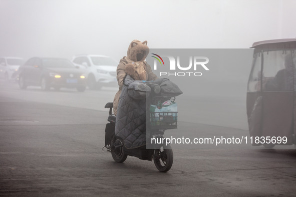 Cars travel in heavy fog with visibility of less than 100 meters on a street in Hua County, Anyang, China, on December 5, 2024. 