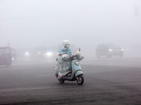 Citizens ride in heavy fog with visibility of less than 100 meters on a street in Hua County, Anyang, China, on December 5, 2024. (