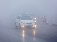 Cars travel in heavy fog with visibility of less than 100 meters on a street in Hua County, Anyang, China, on December 5, 2024. (