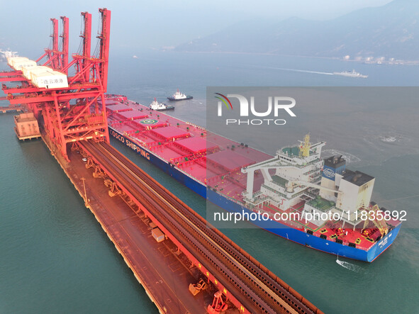 A Singapore-registered ship carrying 400,000 tons of iron ore is unloaded at a berth in Lianyungang port in Jiangsu province, China, on Dece...