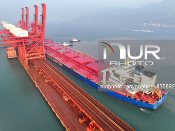 A Singapore-registered ship carrying 400,000 tons of iron ore is unloaded at a berth in Lianyungang port in Jiangsu province, China, on Dece...