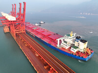 A Singapore-registered ship carrying 400,000 tons of iron ore is unloaded at a berth in Lianyungang port in Jiangsu province, China, on Dece...