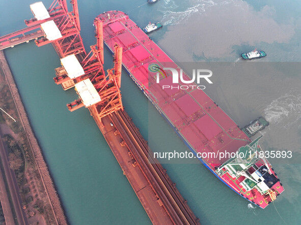 A Singapore-registered ship carrying 400,000 tons of iron ore is unloaded at a berth in Lianyungang port in Jiangsu province, China, on Dece...