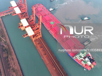 A Singapore-registered ship carrying 400,000 tons of iron ore is unloaded at a berth in Lianyungang port in Jiangsu province, China, on Dece...