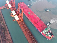 A Singapore-registered ship carrying 400,000 tons of iron ore is unloaded at a berth in Lianyungang port in Jiangsu province, China, on Dece...