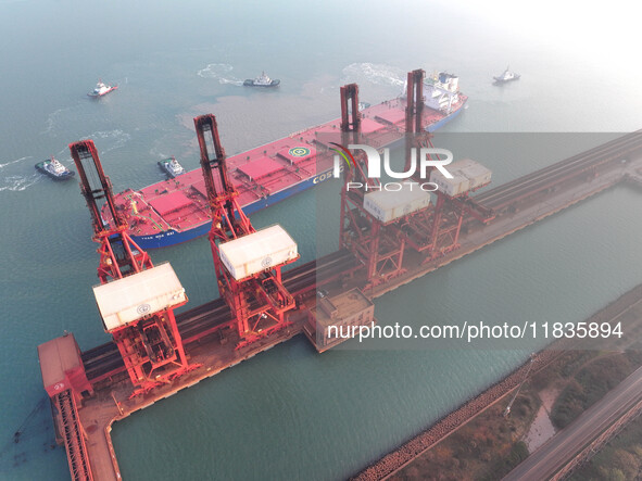 A Singapore-registered ship carrying 400,000 tons of iron ore is unloaded at a berth in Lianyungang port in Jiangsu province, China, on Dece...