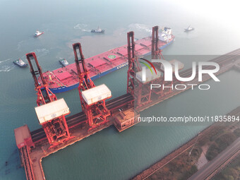 A Singapore-registered ship carrying 400,000 tons of iron ore is unloaded at a berth in Lianyungang port in Jiangsu province, China, on Dece...