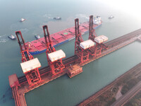 A Singapore-registered ship carrying 400,000 tons of iron ore is unloaded at a berth in Lianyungang port in Jiangsu province, China, on Dece...