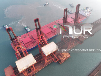 A Singapore-registered ship carrying 400,000 tons of iron ore is unloaded at a berth in Lianyungang port in Jiangsu province, China, on Dece...