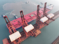 A Singapore-registered ship carrying 400,000 tons of iron ore is unloaded at a berth in Lianyungang port in Jiangsu province, China, on Dece...