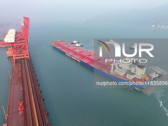 A Singapore-registered ship carrying 400,000 tons of iron ore is unloaded at a berth in Lianyungang port in Jiangsu province, China, on Dece...