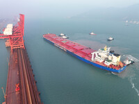 A Singapore-registered ship carrying 400,000 tons of iron ore is unloaded at a berth in Lianyungang port in Jiangsu province, China, on Dece...