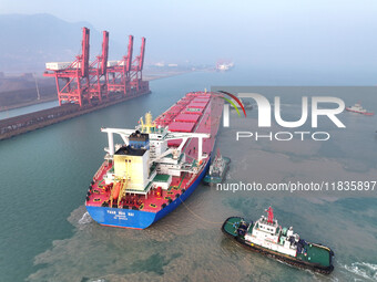 A Singapore-registered ship carrying 400,000 tons of iron ore is unloaded at a berth in Lianyungang port in Jiangsu province, China, on Dece...