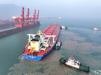 A Singapore-registered ship carrying 400,000 tons of iron ore is unloaded at a berth in Lianyungang port in Jiangsu province, China, on Dece...