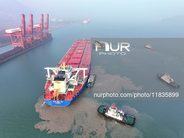 A Singapore-registered ship carrying 400,000 tons of iron ore is unloaded at a berth in Lianyungang port in Jiangsu province, China, on Dece...