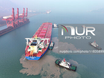 A Singapore-registered ship carrying 400,000 tons of iron ore is unloaded at a berth in Lianyungang port in Jiangsu province, China, on Dece...