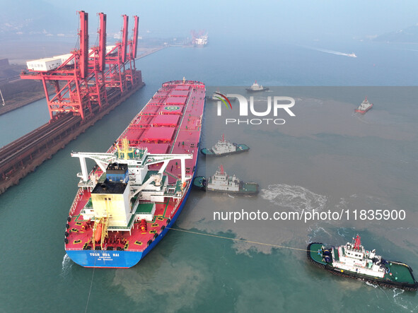 A Singapore-registered ship carrying 400,000 tons of iron ore is unloaded at a berth in Lianyungang port in Jiangsu province, China, on Dece...