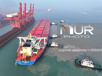 A Singapore-registered ship carrying 400,000 tons of iron ore is unloaded at a berth in Lianyungang port in Jiangsu province, China, on Dece...