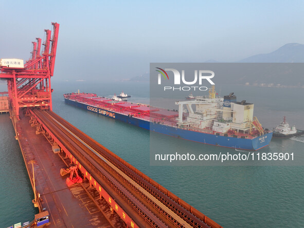 A Singapore-registered ship carrying 400,000 tons of iron ore is unloaded at a berth in Lianyungang port in Jiangsu province, China, on Dece...