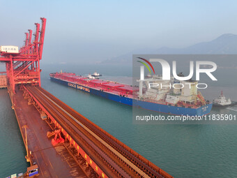 A Singapore-registered ship carrying 400,000 tons of iron ore is unloaded at a berth in Lianyungang port in Jiangsu province, China, on Dece...