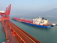 A Singapore-registered ship carrying 400,000 tons of iron ore is unloaded at a berth in Lianyungang port in Jiangsu province, China, on Dece...