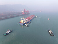 A Singapore-registered ship carrying 400,000 tons of iron ore is unloaded at a berth in Lianyungang port in Jiangsu province, China, on Dece...