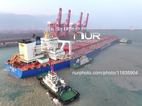 A Singapore-registered ship carrying 400,000 tons of iron ore is unloaded at a berth in Lianyungang port in Jiangsu province, China, on Dece...