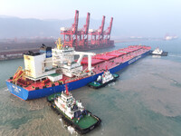 A Singapore-registered ship carrying 400,000 tons of iron ore is unloaded at a berth in Lianyungang port in Jiangsu province, China, on Dece...