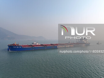 A Singapore-registered ship carrying 400,000 tons of iron ore is unloaded at a berth in Lianyungang port in Jiangsu province, China, on Dece...