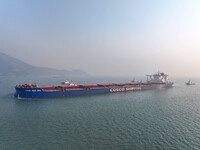 A Singapore-registered ship carrying 400,000 tons of iron ore is unloaded at a berth in Lianyungang port in Jiangsu province, China, on Dece...