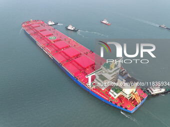 A Singapore-registered ship carrying 400,000 tons of iron ore is unloaded at a berth in Lianyungang port in Jiangsu province, China, on Dece...