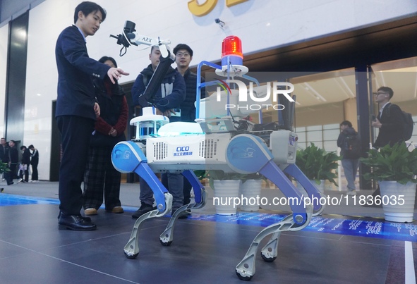 Visitors look at a four-legged intelligent robot (robot dog) that can perform patrols on a highway at the Zhejiang International Intelligent...