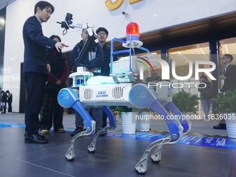 Visitors look at a four-legged intelligent robot (robot dog) that can perform patrols on a highway at the Zhejiang International Intelligent...