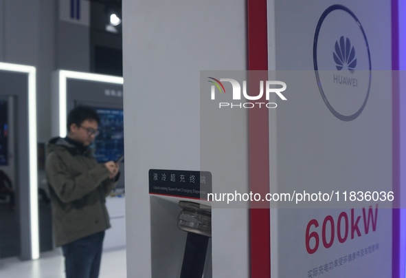 Visitors look at a high-power supercharge DC facility launched by Huawei at the Zhejiang International Intelligent Transportation Industry E...