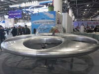 Visitors look at a manned flying saucer electric vertical take-off and landing vehicle (eVTOL) at the Zhejiang International Intelligent Tra...