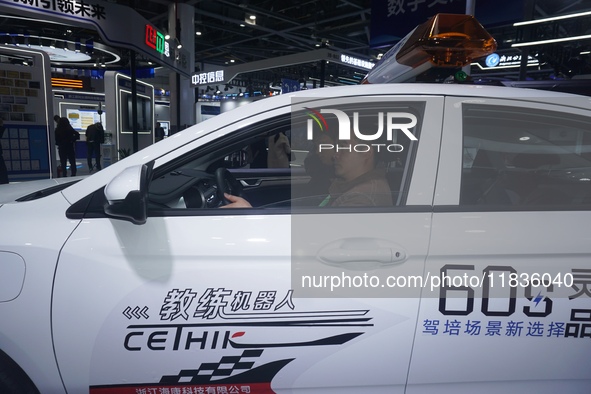 Visitors experience driving learning using a car instructor robot at the Zhejiang International Intelligent Transportation Industry Expo in...