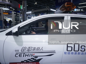 Visitors experience driving learning using a car instructor robot at the Zhejiang International Intelligent Transportation Industry Expo in...