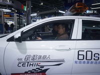 Visitors experience driving learning using a car instructor robot at the Zhejiang International Intelligent Transportation Industry Expo in...