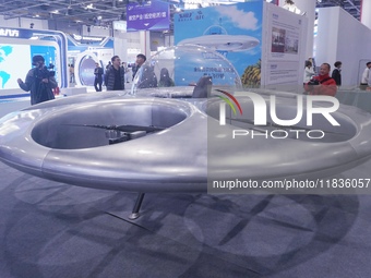 Visitors look at a manned flying saucer electric vertical take-off and landing (eVTOL) at the Zhejiang International Intelligent Transportat...