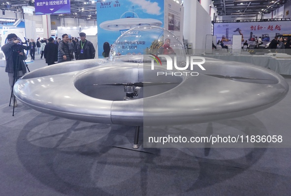 Visitors look at a manned flying saucer electric vertical take-off and landing (eVTOL) at the Zhejiang International Intelligent Transportat...