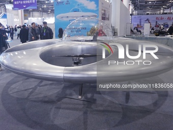 Visitors look at a manned flying saucer electric vertical take-off and landing (eVTOL) at the Zhejiang International Intelligent Transportat...