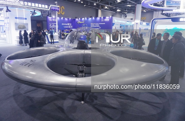 Visitors look at a manned flying saucer electric vertical take-off and landing (eVTOL) at the Zhejiang International Intelligent Transportat...