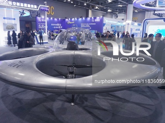 Visitors look at a manned flying saucer electric vertical take-off and landing (eVTOL) at the Zhejiang International Intelligent Transportat...