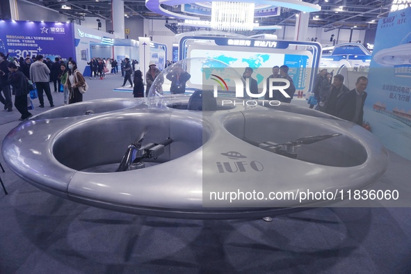 Visitors look at a manned flying saucer electric vertical take-off and landing (eVTOL) at the Zhejiang International Intelligent Transportat...