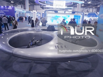 Visitors look at a manned flying saucer electric vertical take-off and landing (eVTOL) at the Zhejiang International Intelligent Transportat...