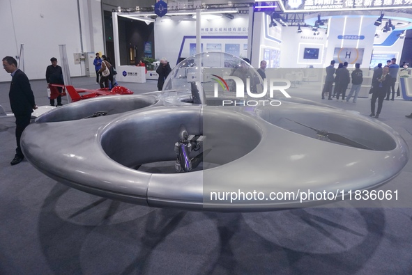 Visitors look at a manned flying saucer electric vertical take-off and landing (eVTOL) at the Zhejiang International Intelligent Transportat...